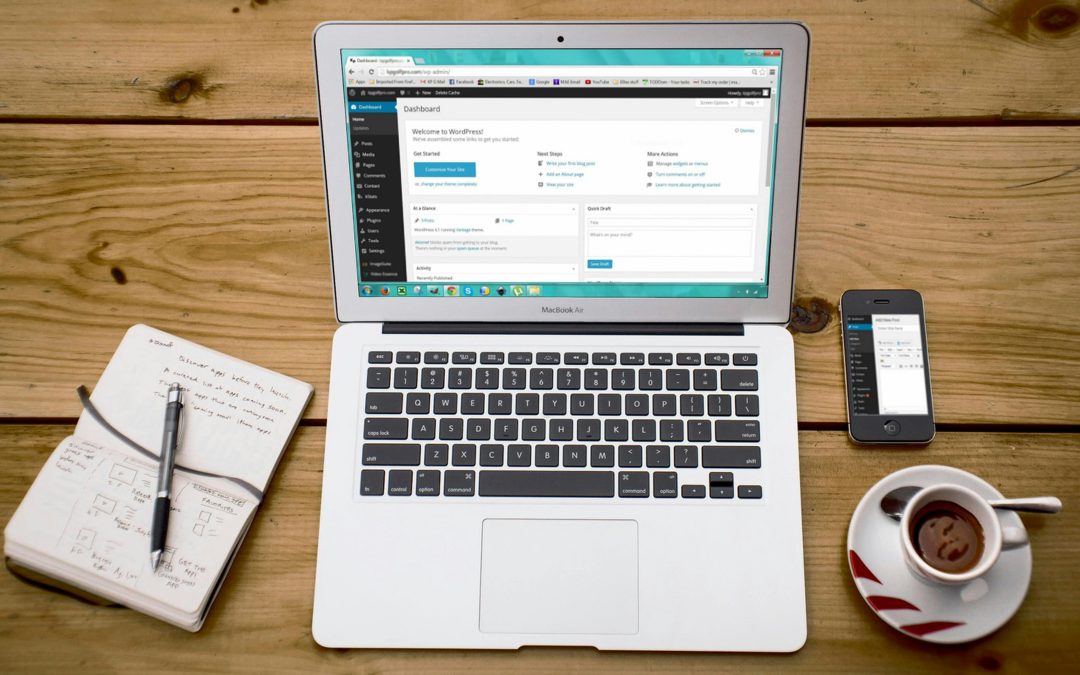 Turned-on Macbook Air Beside Black Iphone 4, Cup of Tea, and Notebook on Brown Wooden Surface