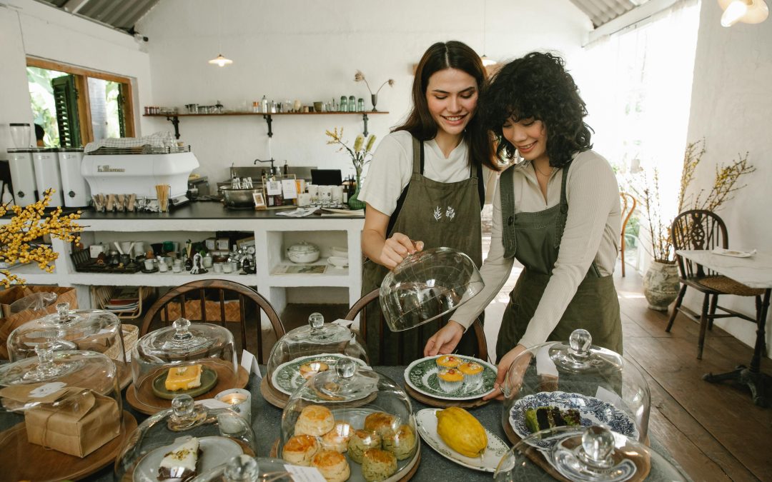 Happy women serving desserts in cafe